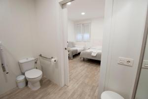 a white bathroom with a toilet and a bedroom at Pension MD in San Sebastián +45 photos