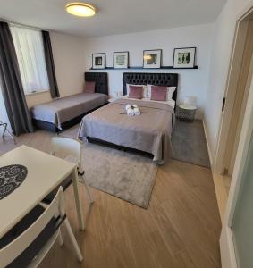 a bedroom with two beds and a table and chairs at Blue Star Apartments in Dubrovnik