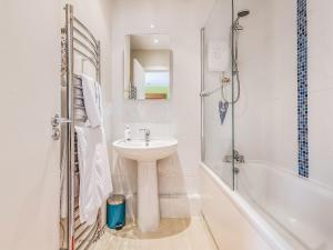 a white bathroom with a sink and a shower at Dunlin Haven in Sandside