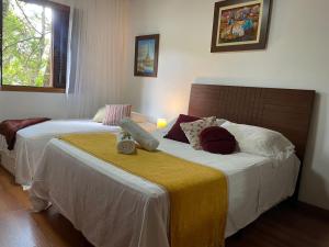 2 letti in camera d'albergo con di Casa Oásis: Requinte, Paz e Conforto na Natureza ad Atibaia