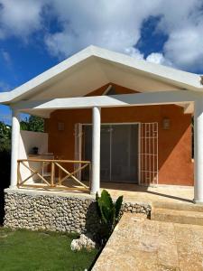 una pequeña casa con techo blanco en Casita Cayena en Las Galeras