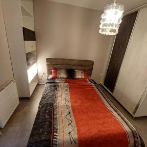 a large bed in a room with a chandelier at Apartman Irena in Loznica
