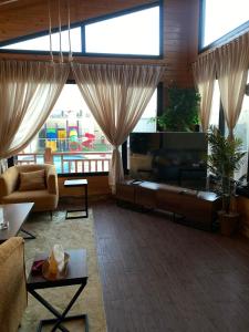 un soggiorno con divano e TV in camera di أكواخ وشاليهات ذا فيلج - The village a Khalij Salman