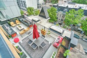 einen Luftblick auf eine Terrasse mit Stühlen und einem Sonnenschirm in der Unterkunft Liv MTL Downtown in Montreal