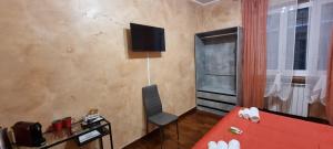 1 dormitorio con cama roja y TV en la pared en Wanderlust Pietralata B&B, en Roma