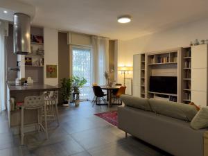 uma sala de estar e cozinha com um sofá e uma mesa em Cozy Apartment close to Milan Rho Fair MIND em Rho