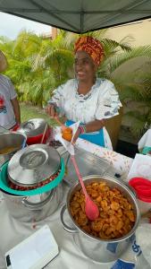 une femme agite un pot de nourriture avec une cuillère dans l'établissement Loft Beira Mar, à Camassari