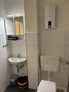 La petite salle de bains est pourvue de toilettes et d'un lavabo. dans l'établissement TraumAppartment, à Mönchengladbach