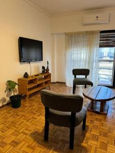 Una sala de estar con un televisor y una mesa y sillas. en Hermoso y amplio departamento, en Buenos Aires