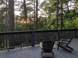 a bench and a table on a deck with trees at Loblolly Pines Adventure Cabin 4 King in Eureka Springs