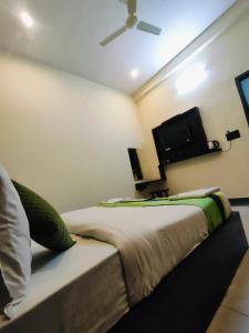a bedroom with a bed and a flat screen tv at Hotel Spiritual Land in Mathura