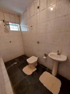 a bathroom with a toilet and a sink at Casa inteira no centro de São Thomé das letras in São Thomé das Letras