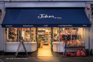 eine Ladenfront mit einer blauen Markise in der Unterkunft Catboat Cottage in Appledore