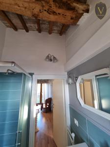 baño con paredes azules y espejo en Vesionica Holiday House, en Civitella Benazzone