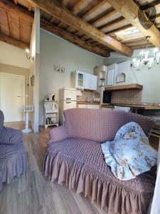 sala de estar con sofá púrpura y cocina en Vesionica Holiday House, en Civitella Benazzone