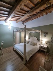 1 dormitorio con cama blanca y suelo de madera en Vesionica Holiday House, en Civitella Benazzone