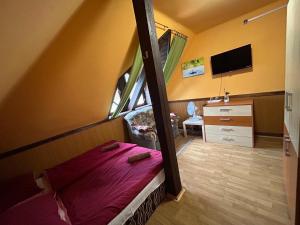 - une chambre avec des lits superposés et une télévision dans l'établissement Vakáció Üdülő, à Révfülöp