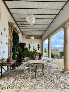 un patio con mesa, sillas y techo en Villa Dell'Annunziata, en Rieti