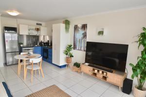a living room with a large television and a table at City Stadium One Bedroom Luxe in Townsville
