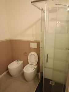 a bathroom with a toilet and a glass shower at Affittacamere Nonna Ida in Carpi