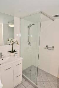 a shower with a glass door in a bathroom at City Stadium One Bedroom Luxe in Townsville
