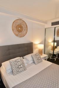 a bedroom with a large bed with two pillows at City Stadium One Bedroom Luxe in Townsville