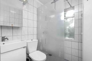 a white bathroom with a toilet and a sink at Bright and Beautiful House in Reykjavík