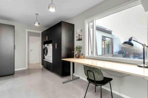 a kitchen with a desk and a window and a refrigerator at Bright and Beautiful House in Reykjavík