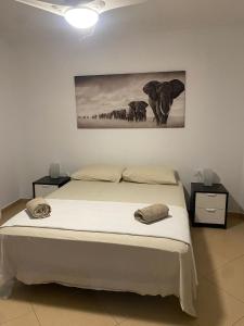 um quarto com uma cama com um quadro na parede em Los Cristianos, Tenerife em El Guincho
