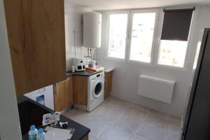 a small kitchen with a washing machine and a window at Piso acogedor céntrico in Albacete