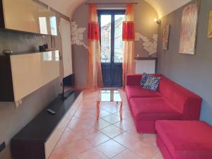 ein Wohnzimmer mit einem roten Sofa und einem Tisch in der Unterkunft Nel Cuore Pulsante della Città! in Alessandria