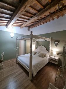 a bedroom with a white bed and a wooden floor at Vesionica Holiday House Perugia in Civitella Benazzone
