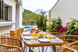 a table with food and orange juice on a patio at One Sweet World in Calheta