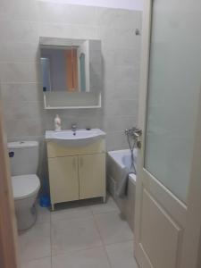 y baño con lavabo, aseo y espejo. en Cazare Apartament 2 camere Militari, en Chiajna
