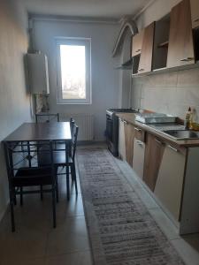cocina con mesa, mesa y sillas en Cazare Apartament 2 camere Militari en Chiajna