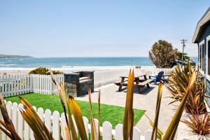 a backyard with a white fence and the beach at Dillon Beach Resort in Dillon Beach