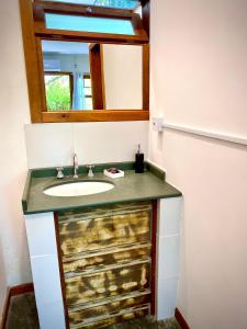 a bathroom with a sink and a mirror at Pousada Tulipane Florianopolis in Florianópolis