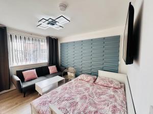 een slaapkamer met een bed en een bank bij City Studio Apartment Swansea - Includes Free Parking in Swansea