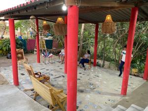een patio met rode palen en mensen die in stoelen zitten bij Alojamiento Rural Las Melinas 