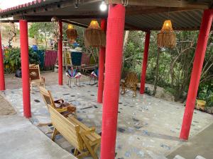 een paviljoen met rode zuilen en een stoel eronder bij Alojamiento Rural Las Melinas 