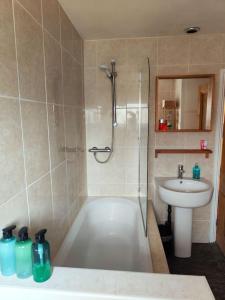 a bathroom with a shower and a tub and a sink at Sofia's Place in Rugby