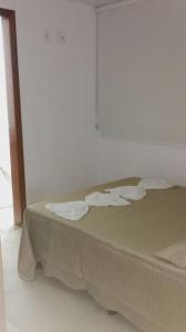 a bed in a room with paper towels on it at Apart° Grande Lar in Guarapari