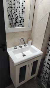 ein Badezimmer mit einem weißen Waschbecken und einem Spiegel in der Unterkunft Departamento Pichincha in Rosario