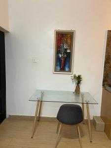 a glass table with a chair and a picture on a wall at SUCCESS ROSE - East Legon, Adjiringanor in Accra