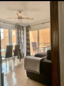 uma sala de estar com uma cama, uma mesa e cadeiras em Затишна квартира Playa Levante em Santa Pola