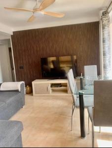 uma sala de estar com uma televisão, uma mesa e um sofá em Затишна квартира Playa Levante em Santa Pola