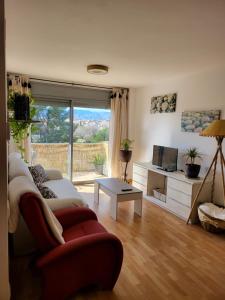 ein Wohnzimmer mit einem Sofa und einem TV in der Unterkunft Apartamento VALLFOGONA Relax in Santa Bàrbara