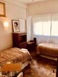 ein Hotelzimmer mit 2 Betten und einem Fenster in der Unterkunft Buenos Aires Apartment in Buenos Aires