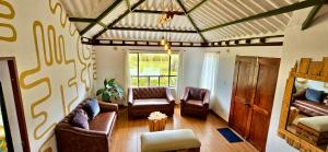 un soggiorno con divani e sedie di Madre Tierra- Casa hospedaje a Villa de Leyva