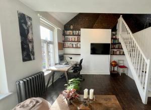 an attic office with a desk and a staircase at Lofty split-level period flat in Highbury in London